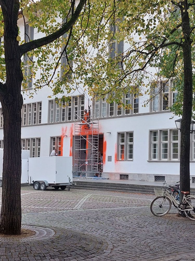 Reinigungsarbeiten am Eingang der Universität Heidelberg, nachdem am Vortag Klimakleber diesen mit orangener Farbe beschmiert hatten.