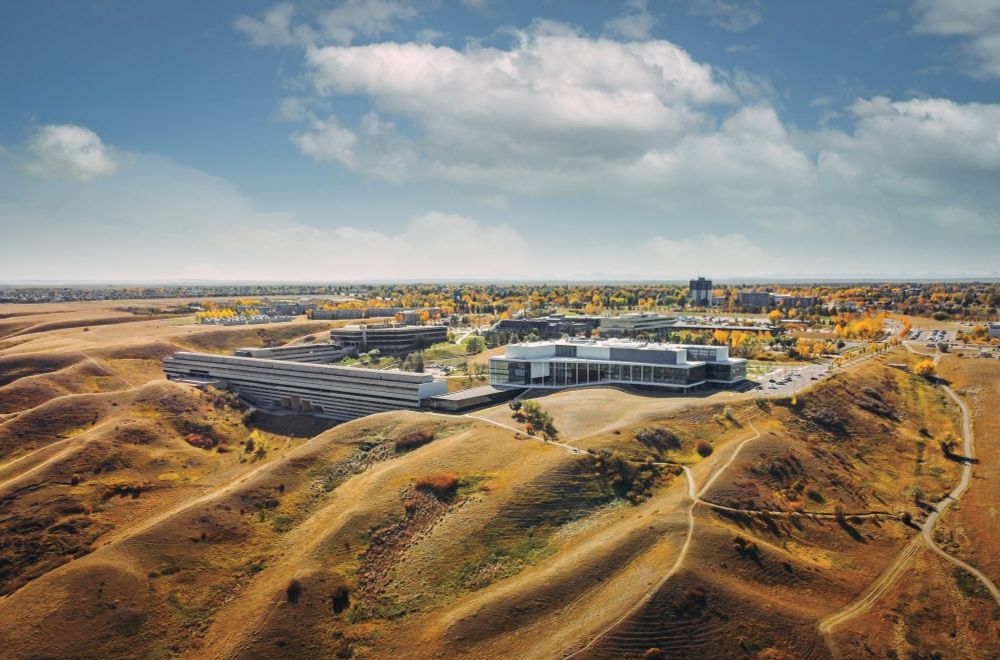Aerial view of the University of Lethbridge. The modern campus buildings are tucked into the gaps between the coulees. 