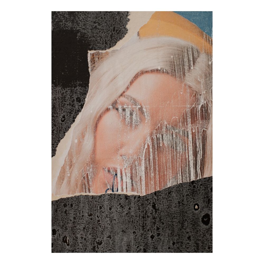 Torn posters leaving part of a blonde woman's face surrounded by jagged black and scraps of yellow and blue. It's covered with streaks of poster paste which has blanked out her eyes and made her look pale and ghostly.