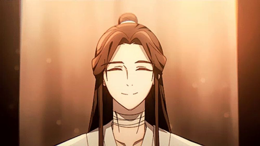 a woman with long hair and a bun is smiling with her eyes closed