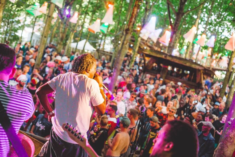 Flinty Badman on the mic in front of the Tangled Woods crows at Boomtown. I think this was early evening on the Sunday and people looked pretty worse for wear. I remember a guy collapsing in the wet mud in front of the jeep which drove us to the stage. There was a lot of katamine going around, from what I recall