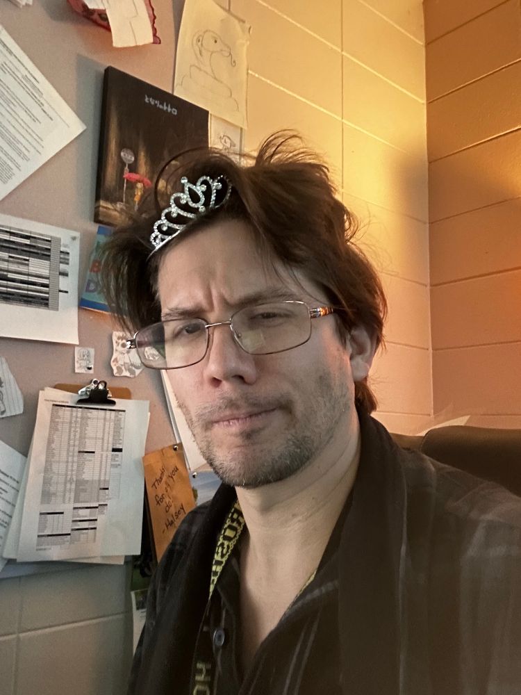 me with disheveled hair and a tiara while wearing a flannel robe and pjs 