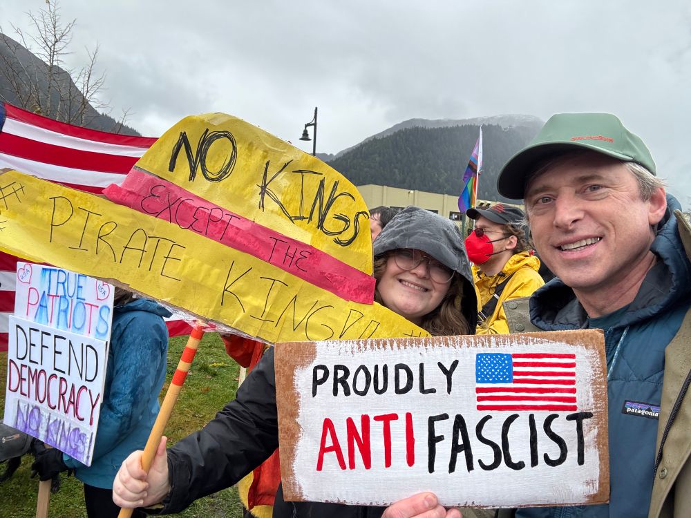 No Kings No Tsars rally Juneau, Alaska, Oct 18 2025. Protestor with signs, “Proudly Antifascist” and “No Kings but the Pirate King”