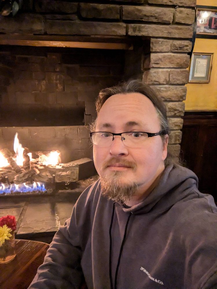 Selfie of Johnicholas in front of a fireplace.