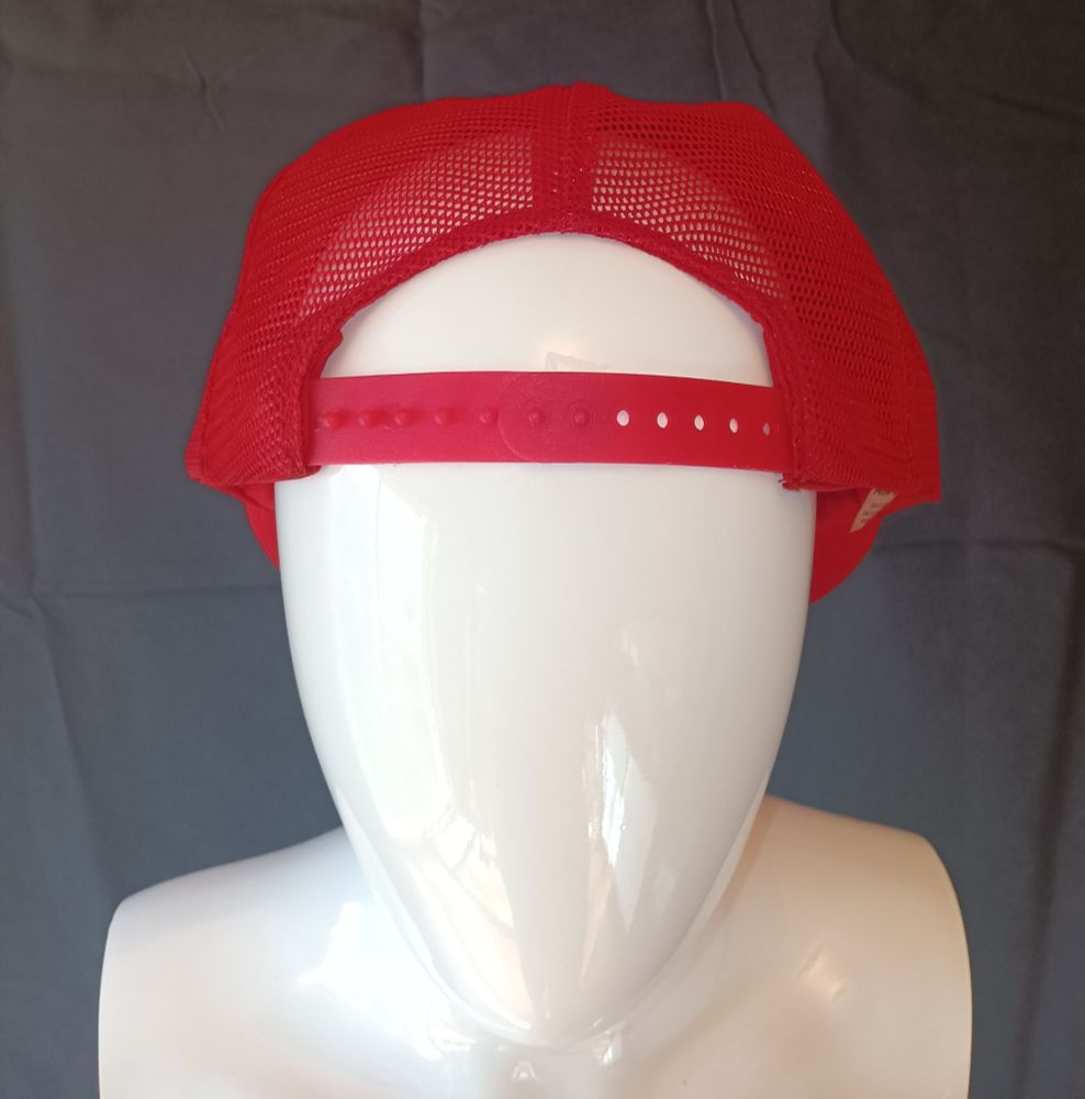 White fiberglass mannequin head in backward red vintage trucker hat