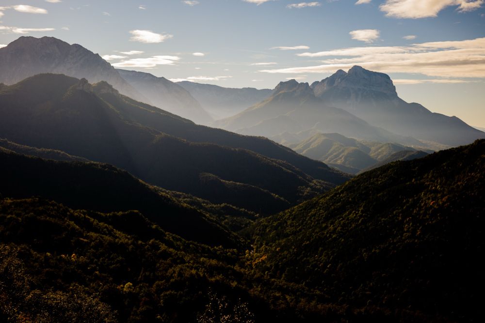 panoramic view over forest and several mountains shrouded in fog