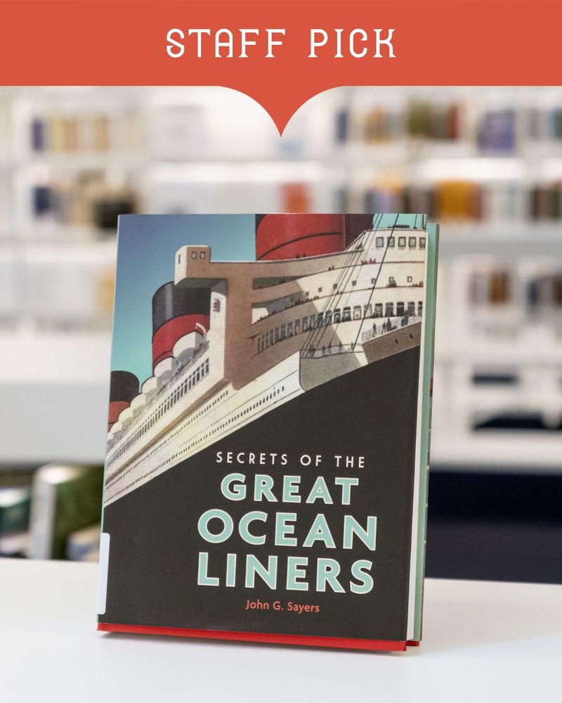 Text: Staff pick. Background image: Book titled "Secrets of the great ocean liners" by John G. Sayers, displayed in a library setting.