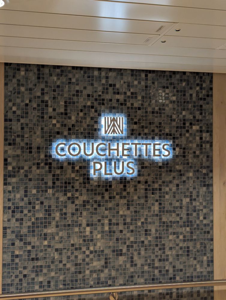Tile effect wall decoration with backlit Couchettes Plus sign.
