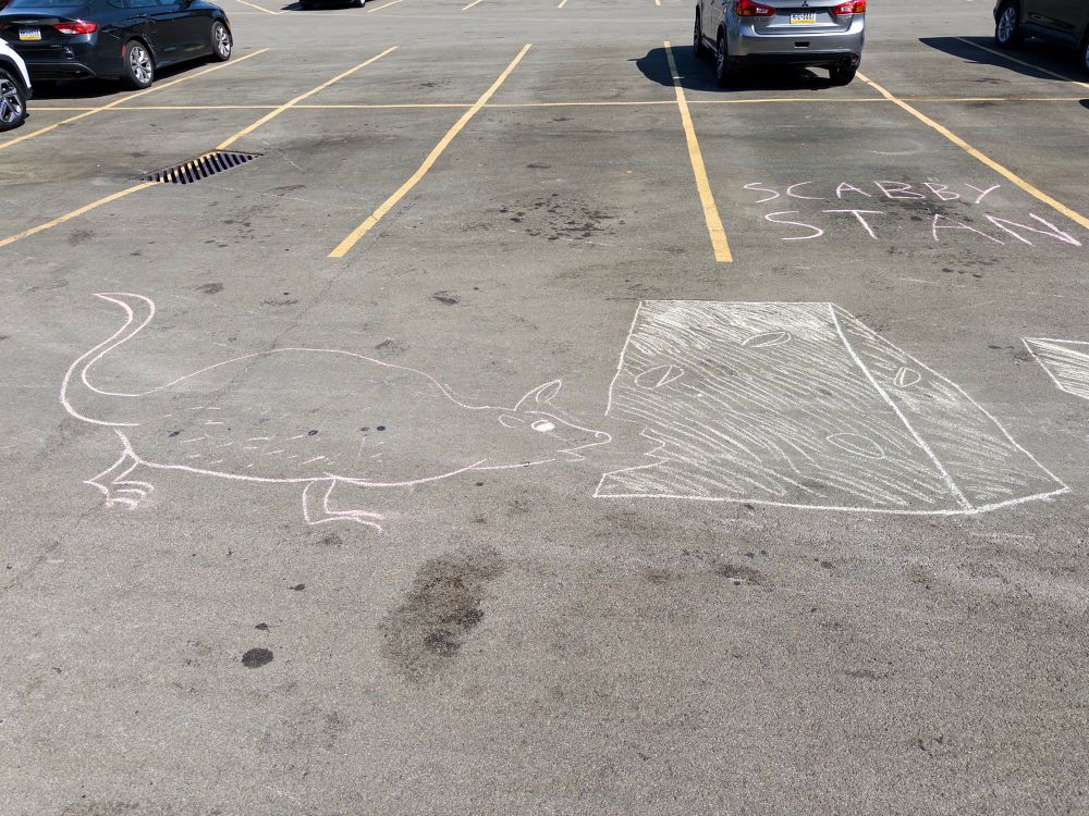 A chalked rat eating cheese drawn onto pavement. 