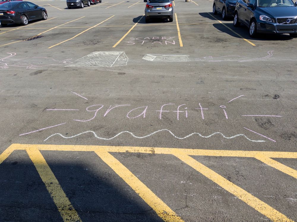 “graffiti” chalked onto pavement. 