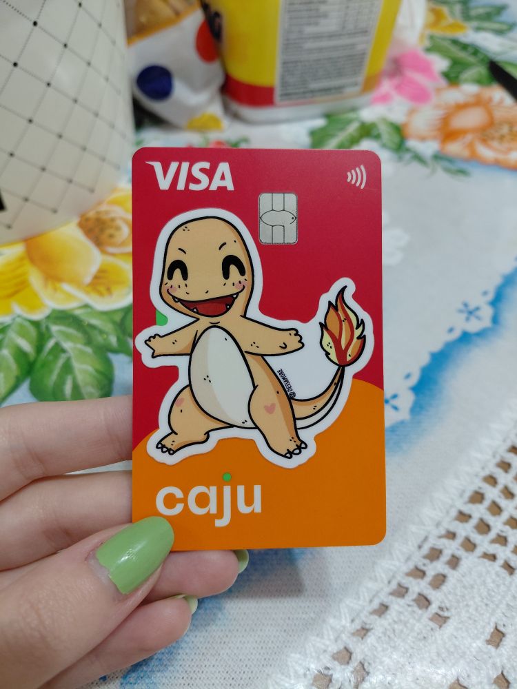 cartão de alimentação caju com um adesivo do charmander colado