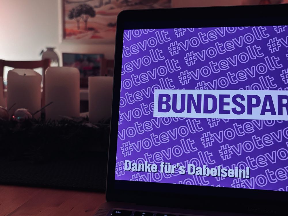 Abendstimmung, Rechner mit Schlussbildschirm zum Volt-Online Bundesparteitag und Text "Danke für's Dabeisein", dahinter 3 erloschene Adventskerzen.
