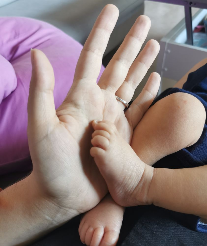 Foto de la palma de la mano de May con el piecito de Dorian 💙