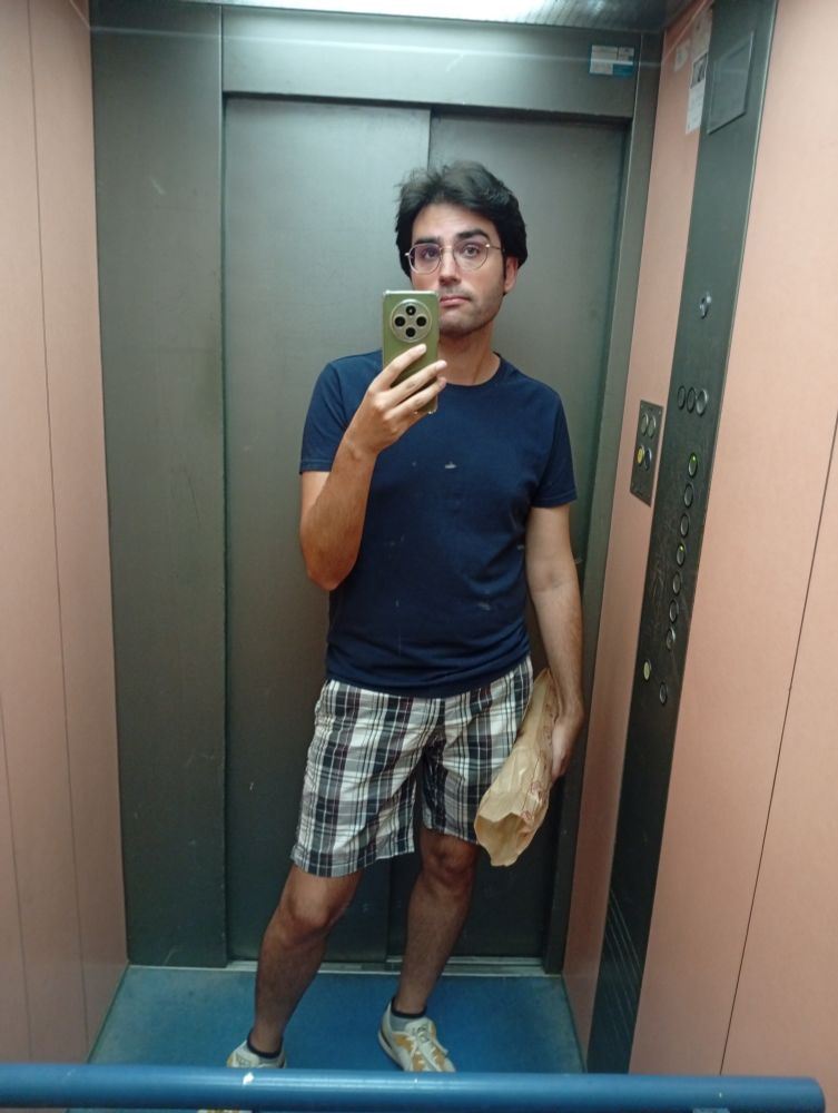 Yo posando en el espejo del ascensor con la barra de pan 