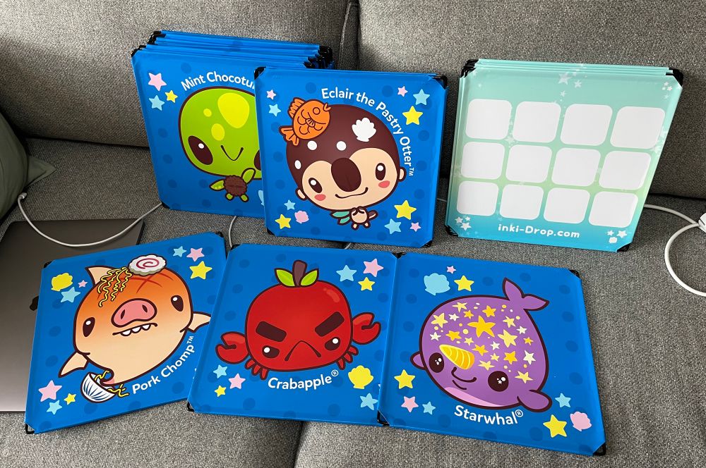 Photo of colorful panels featuring cute animal characters (sea turtle, pig shark, crab, sea otter, narwhal) against a light gray sofa 