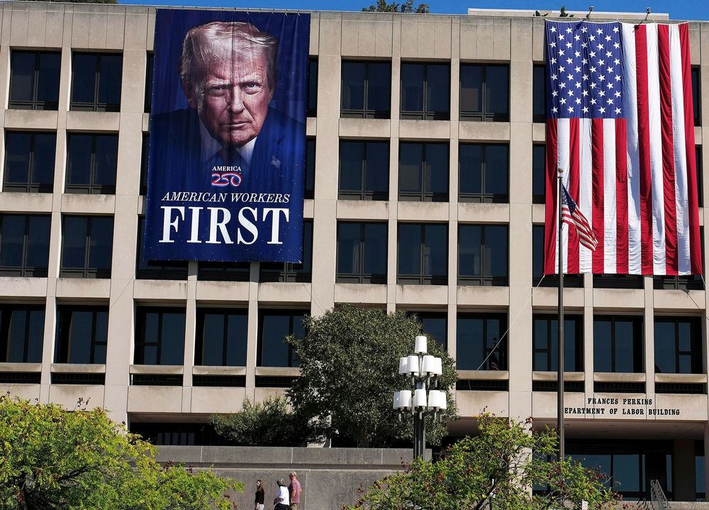 massive 50 foot banner of the president's face hangs on the labor building in DC among a few others 