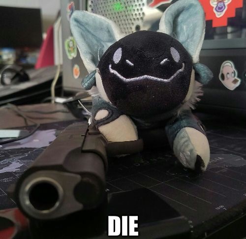 White protobean sitting on an M1911 semi-auto pistol, the barrel is pointed at the camera. Bottom caption says "DIE"