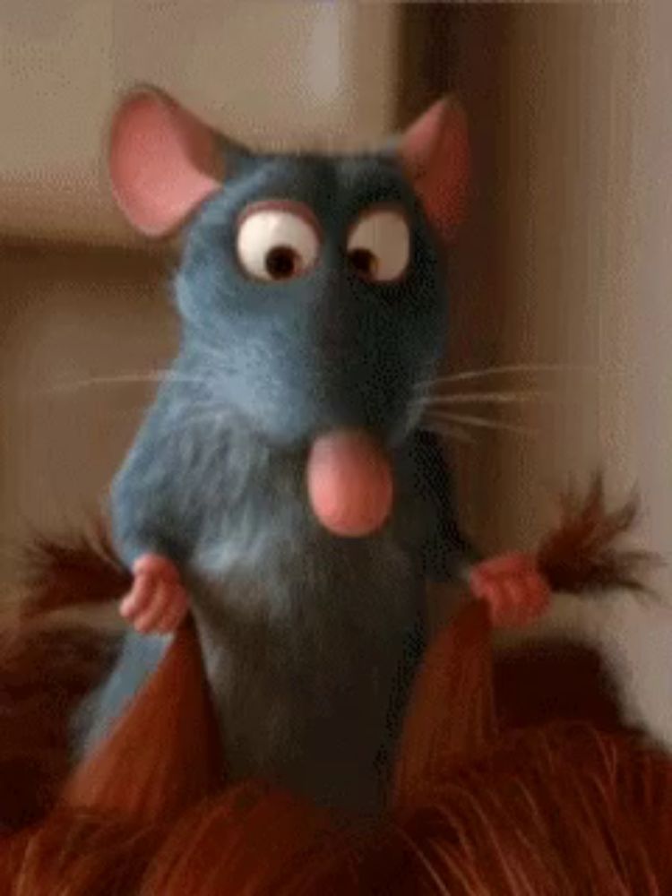 a close up of a cartoon mouse holding a pair of hair brushes .