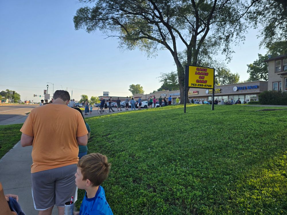 A line to get into a small store that's about 100 people long.