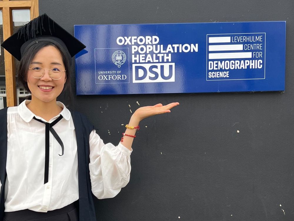 Xinyi Zhao standing next to the Leverhulme Centre for Demographic Science sign after her viva
