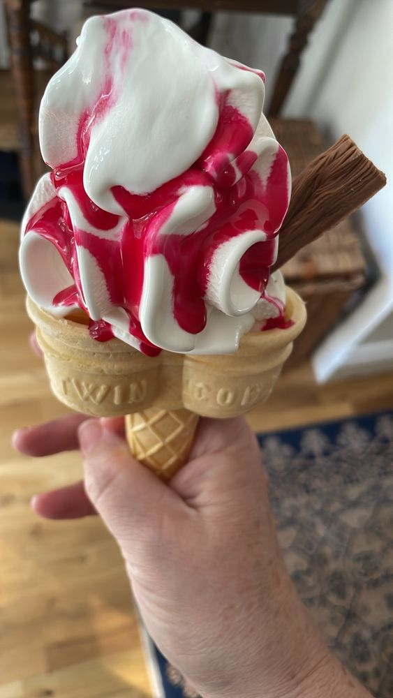 A double ice cream poke (cone) with red sauce and a chocolate flake bar. 