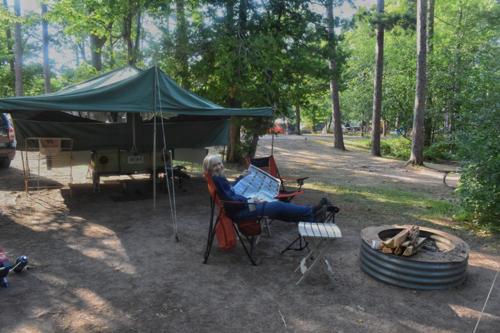 A campsite with a pop-up trailer. 