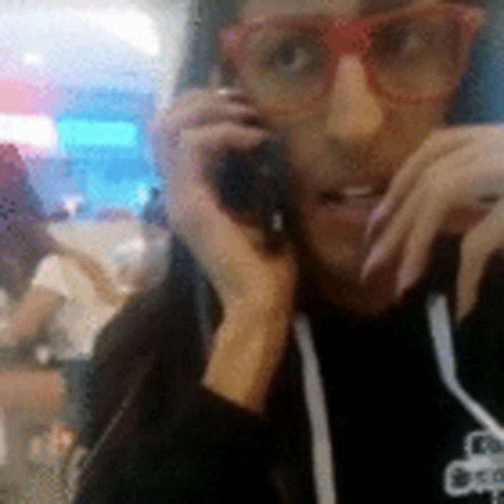 a woman with glasses is talking on a cell phone .