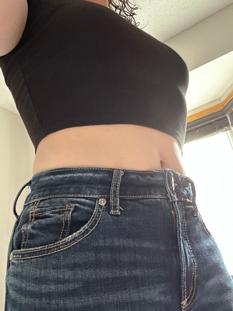 I'm wearing jeans and a tight black cropped shirt with midriff showing
