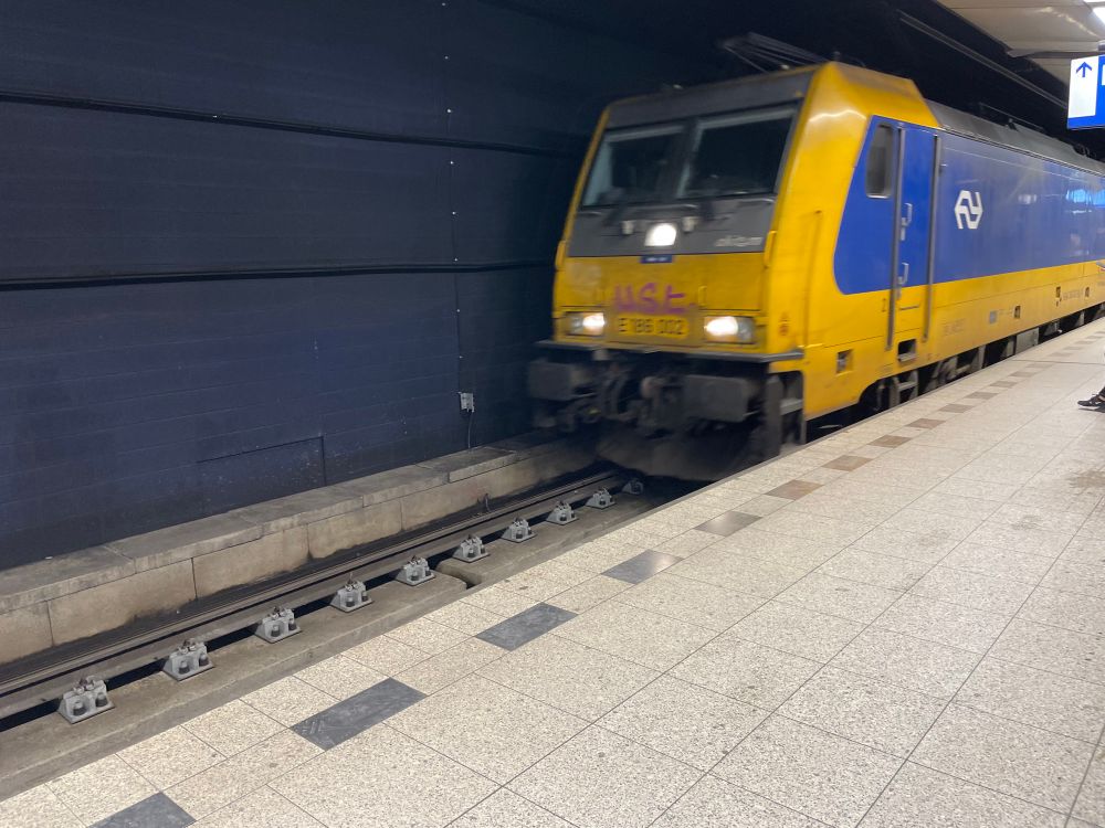 A TRAXX locomotive in NS livery pulling into the underground station of Schiphol Airport. 
