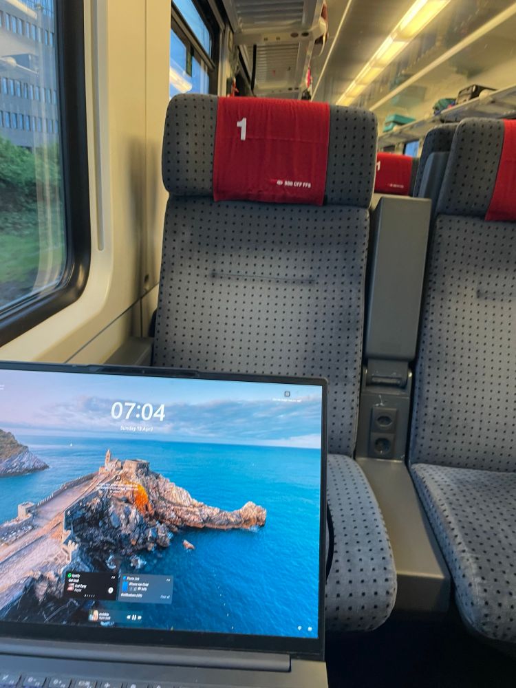 A laptop showing the time (07:04) and a first class SBB CFF FFS seat