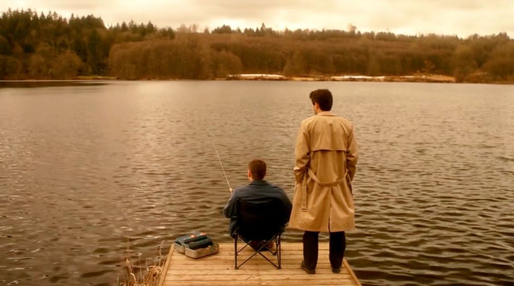 Dean and Castiel on a fishing pier overlooking a lake, The Rapture, Dean is dreaming. Castiel has appeared beside a seated fishing Dean.