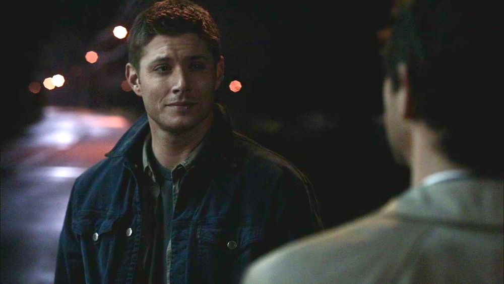 Dean smiling at Castiel, The End. They’re standing by the side of the road.