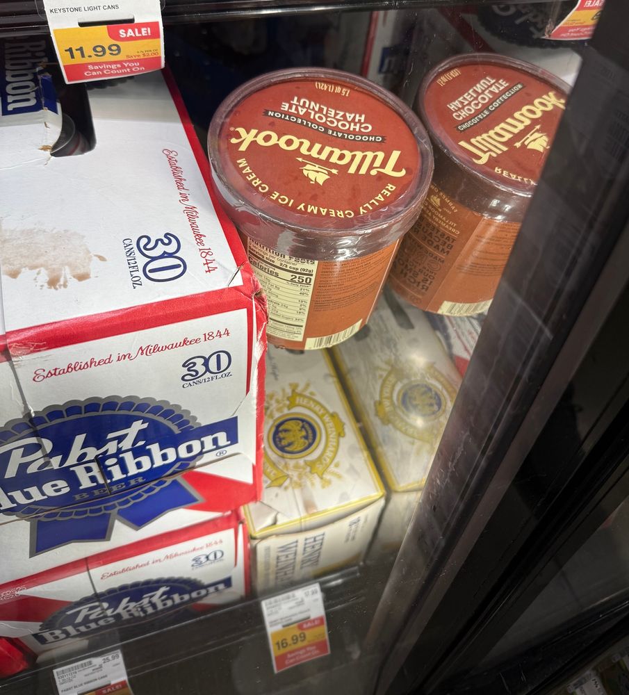 A carton of ice cream wedged into the beer section of the grocery store. Clearly they chose beer over ice cream.