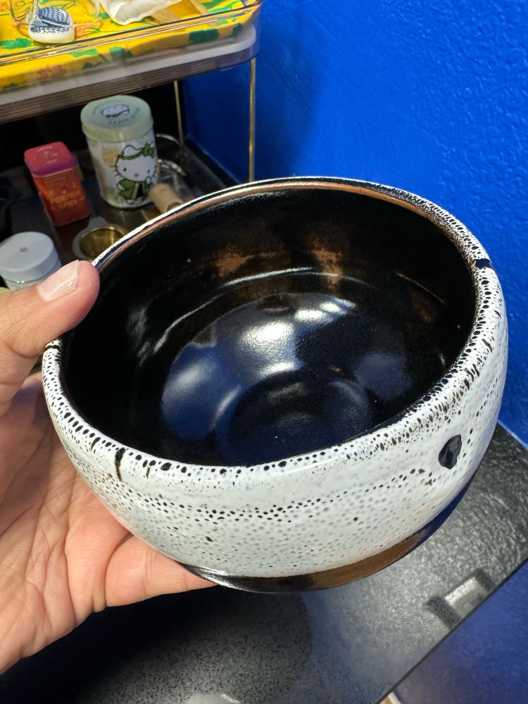 black and white matcha bowl with golden-brown accents