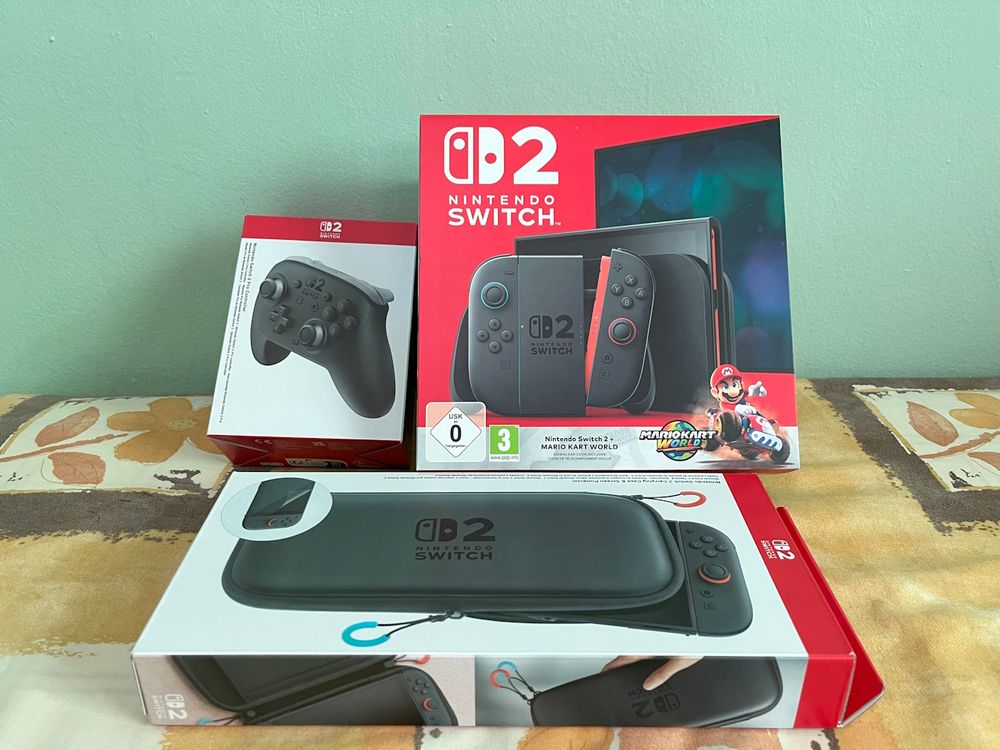 A picture of a Nintendo Switch 2 (MKW bundle), carrying case and Pro Controller; sitting on my bed.