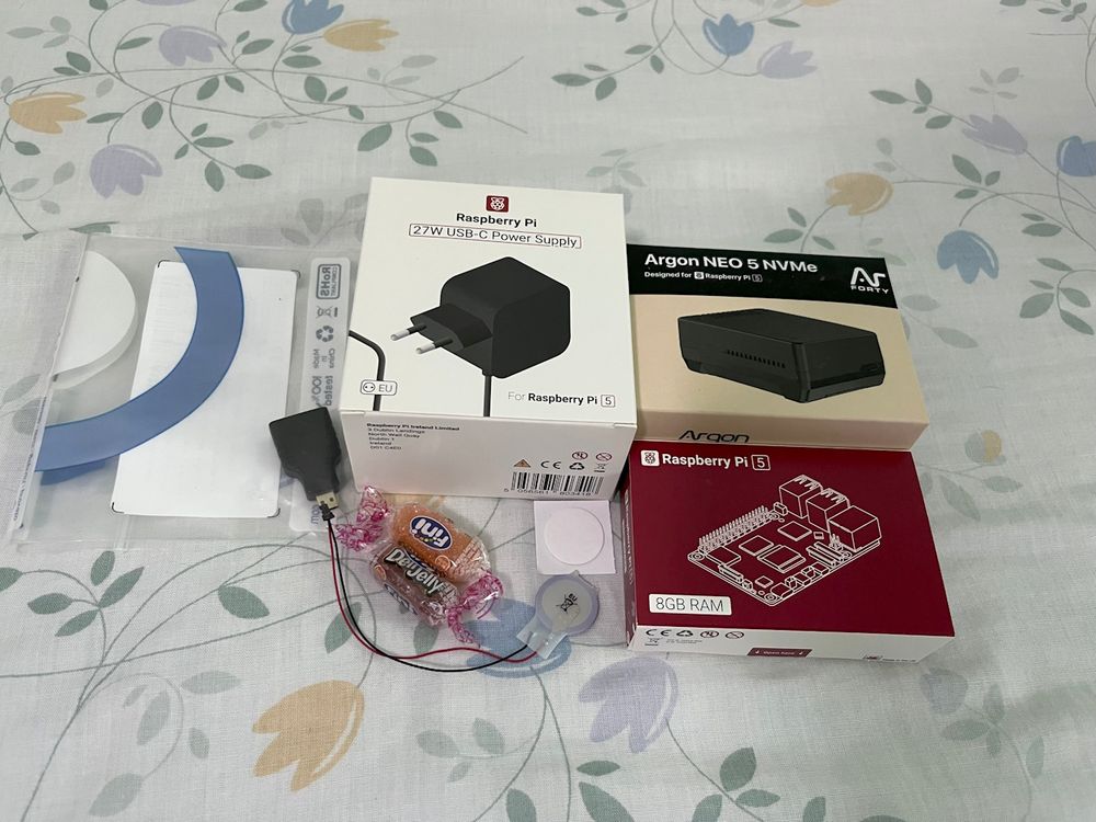 Boxed goodies: Raspberry Pi 5 8GB, Argon NEO 5 NVMe, official power supply and RTC battery, microHDMI to HDMI adapter, freebie candies
