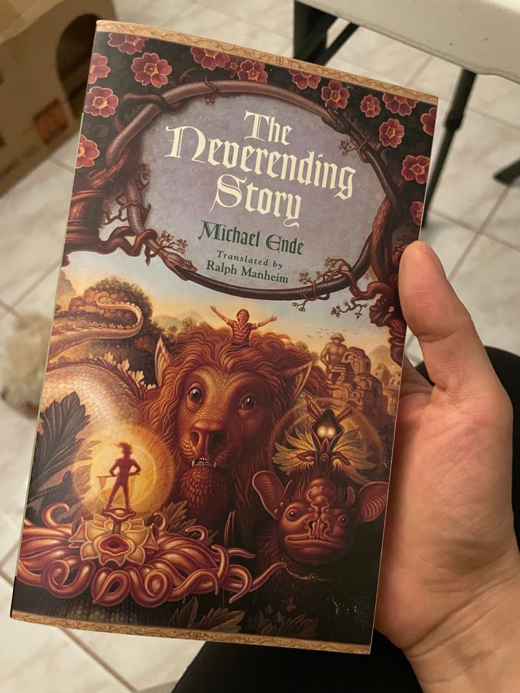 Photo hand holding the book “ The Neverending Story “ by Michael Ende