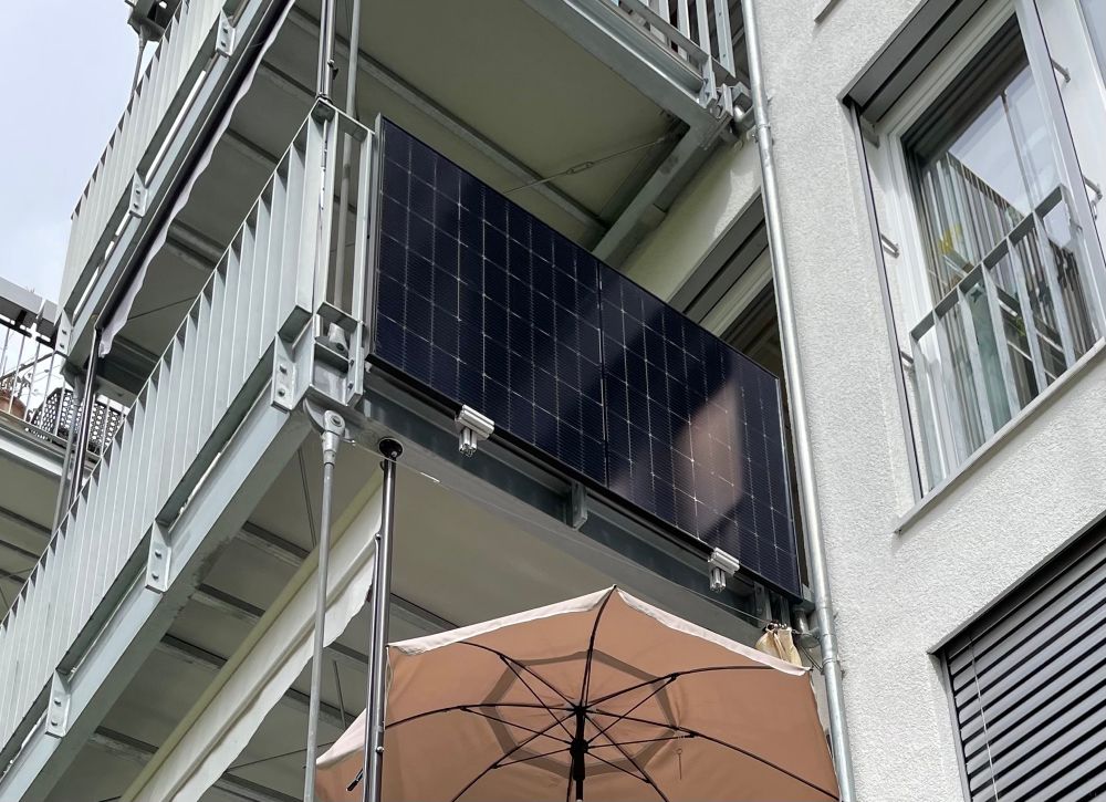 Ein Solarmodul hängt an einem Gitterbalkon