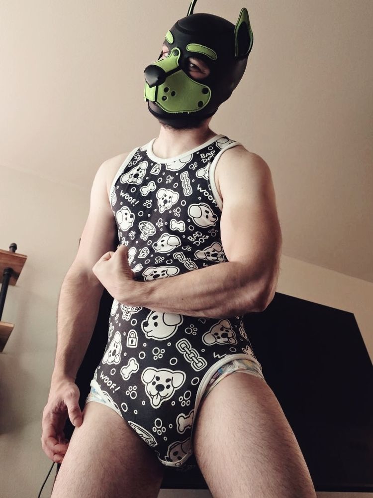 Human pup flexing in a onesie and diaper