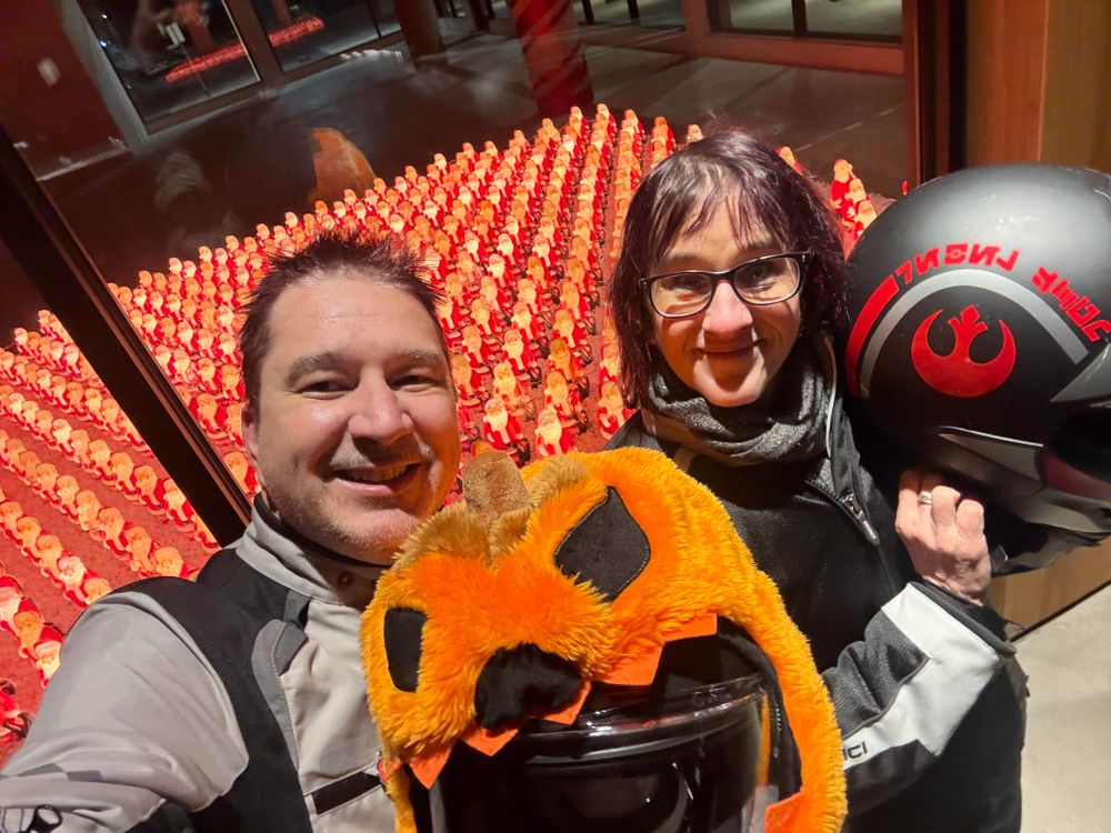 Storefront with hundreds of antique light-up santas. Selfie in front of it.