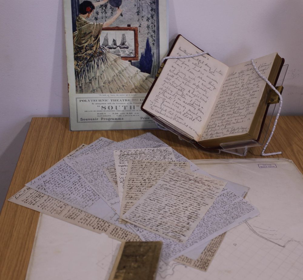 Handwritten notes on paper and in an open book in front of a souvenir programme of a theatre show titled SOUTH.