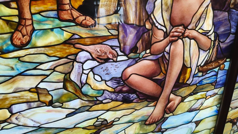 Detail from art glass, showing a sparrow pecking at seeds in a New-Testament-inspired scene. Full piece by Holdman Studios installed at the visitor's center of the Rome Italy temple of the Church of Jesus Christ of Latter Day Saints