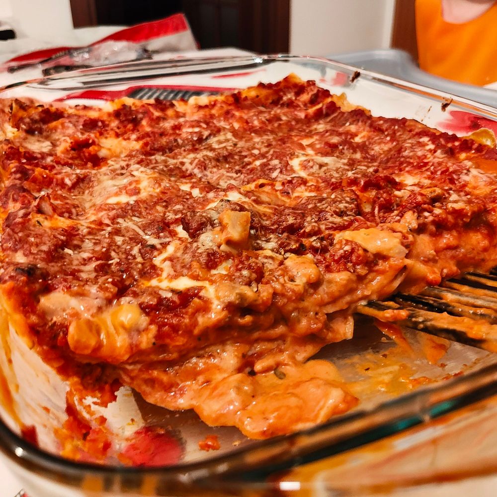 Homemade lasagne viewed from the side, showing layers of pasta and sauces