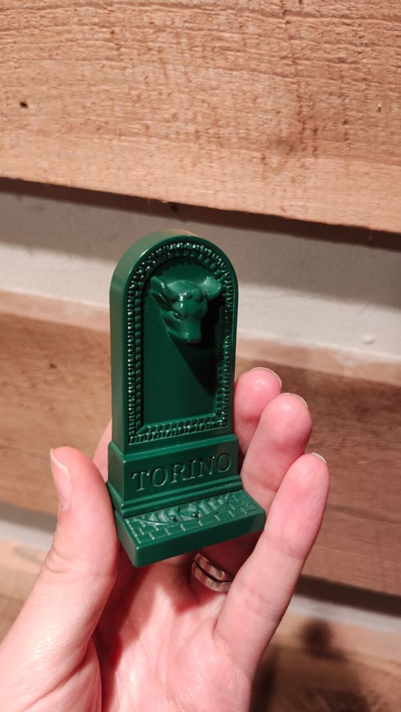 A small (~5cm) plastic model of the drinking fountains found throughout Torino, Italy, which feature a bull's head