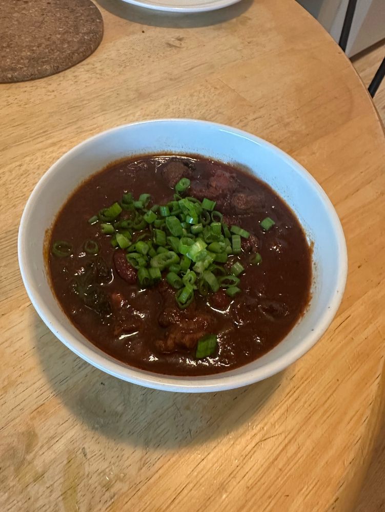 a bowl of chili topped with perhaps too much green onion
