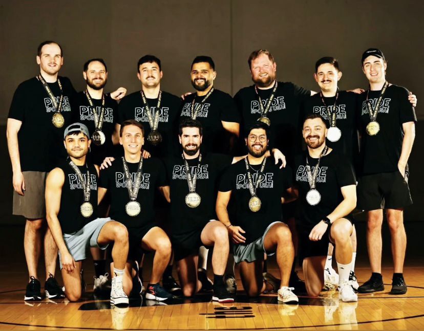 A group of men posing with their gold medals around their necks.