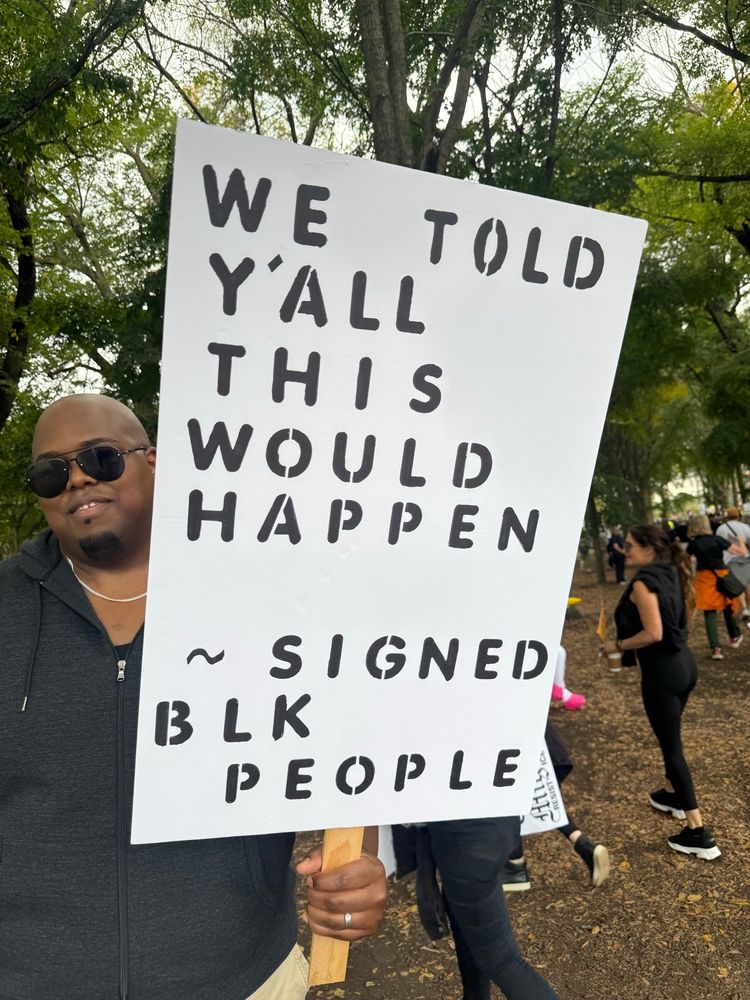 Screenshot:

Black person at the No Kings protest holding a sign that reads, “We Told Y’all This Would Happen” ~ Signed Blk People