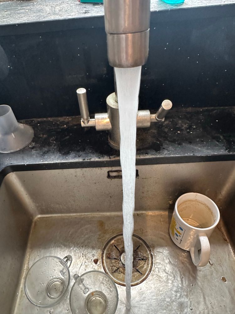 Cold water running from kitchen sink spout. 