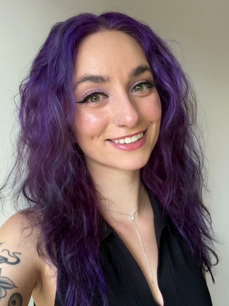 Jupie taking a selfie against a grey wall. 