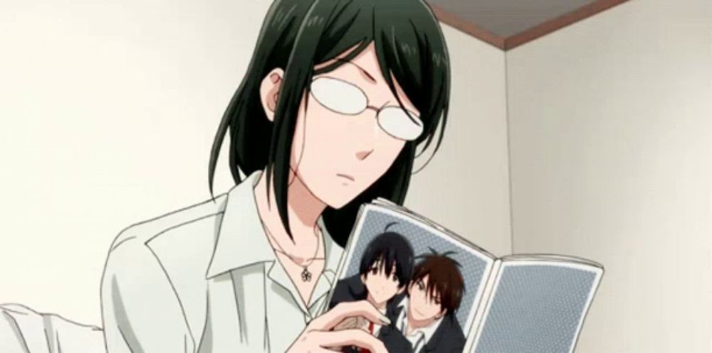 a woman wearing glasses is reading a book with a picture of two men in it .